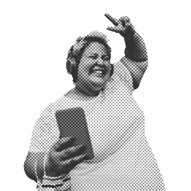 Eine junge Frau mit Kopfhörern auf den Ohren lächelt sehr fröhlich, zeigt mit einer Hand das Peace-Zeichen und hält in der anderen ihr Smartphone