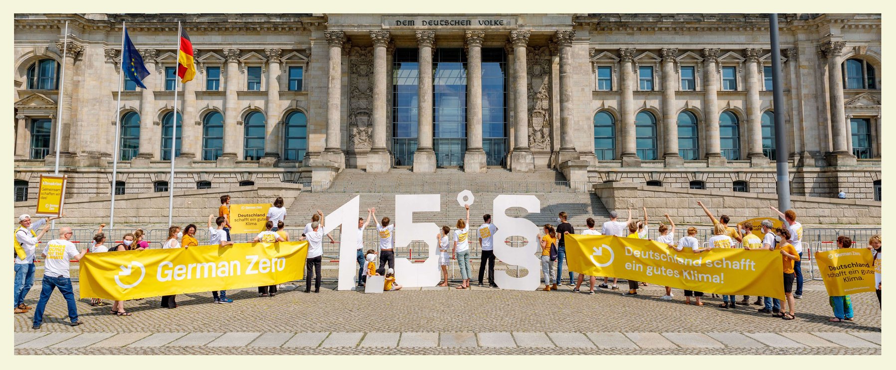 Vor dem Reichstags-Gebäude halten Demonstranten große „1,5°“-Schilder und Banner mit Klimabotschaften hoch.
