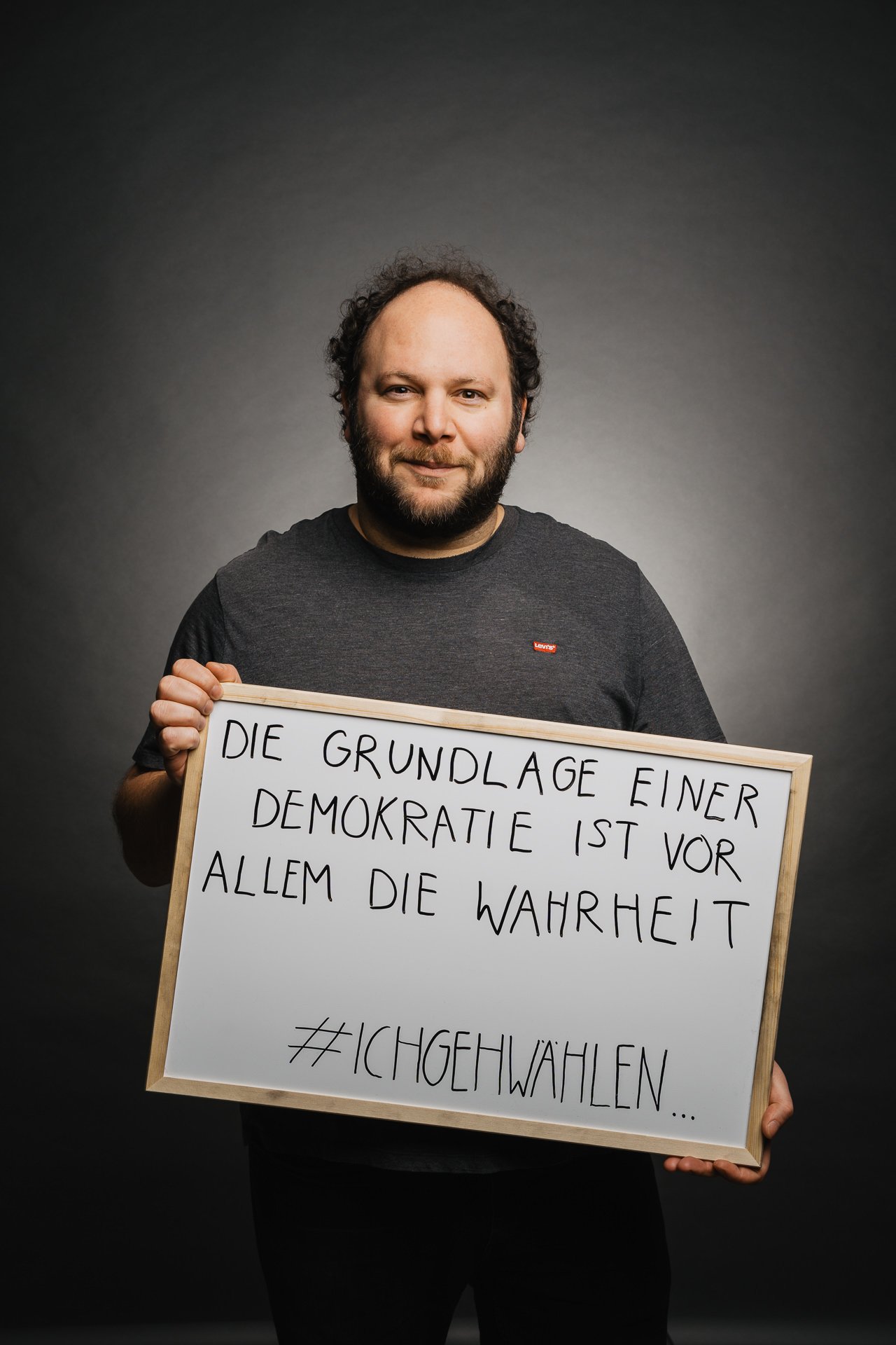 Person, die ein Schild mit deutschem Text über Demokratie und Wahrheit hält, einschließlich des Hashtags #ICHGEHWAHLEN.